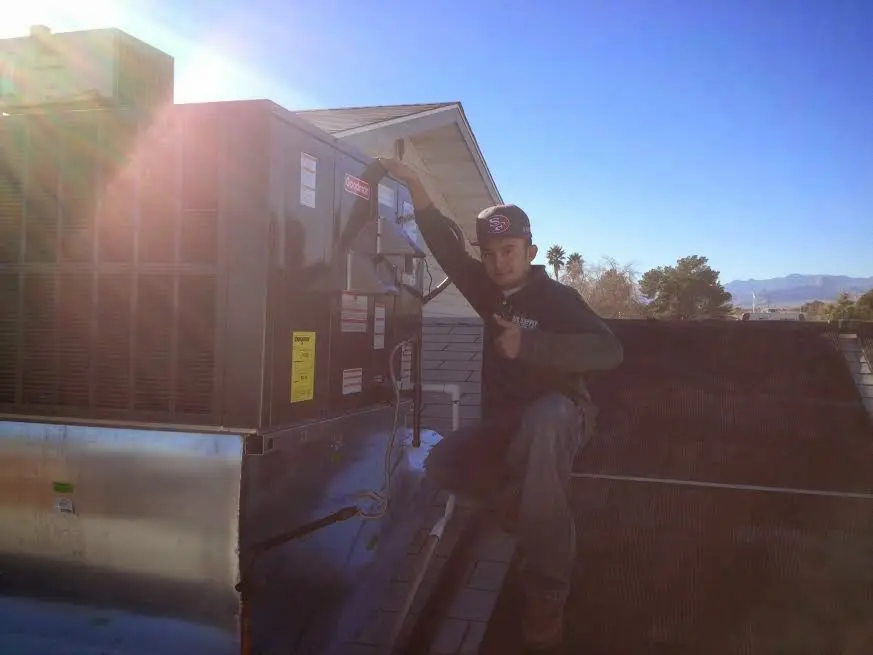 HVAC technician performing AC Tune-Up on a rooftop unit in Rolesville