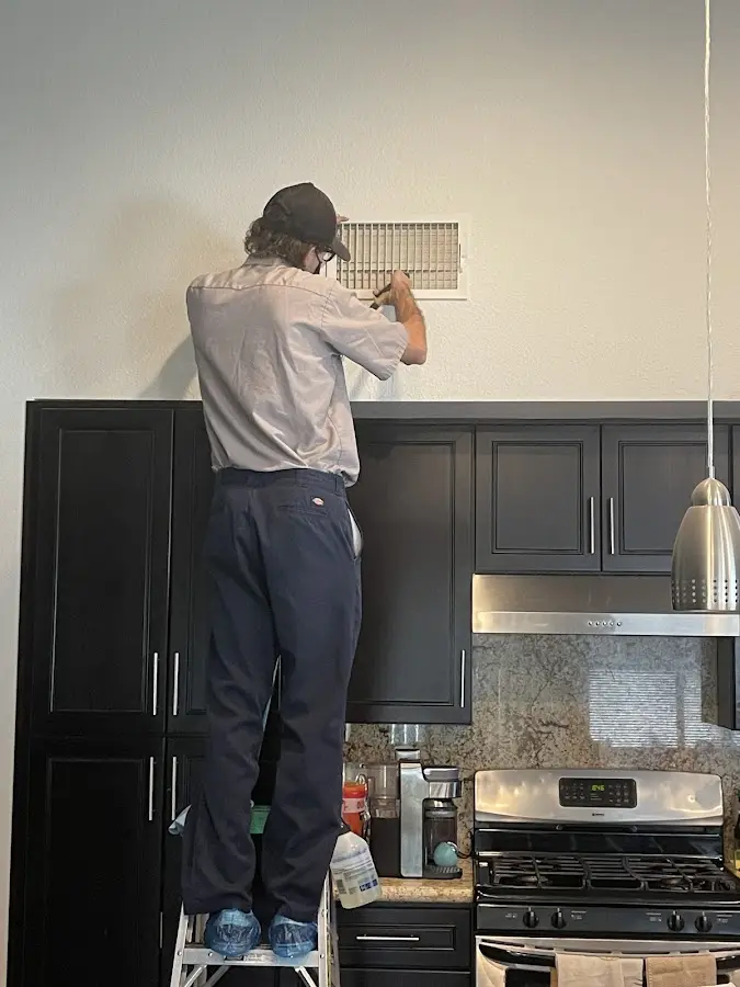 Technician inspecting an air vent during HVAC service in Rolesville